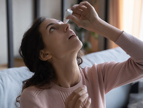 Woman treating her eye with eyedrops